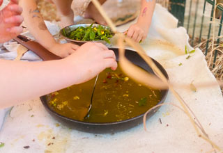 Kinder kochen Suppe mit Kräutern