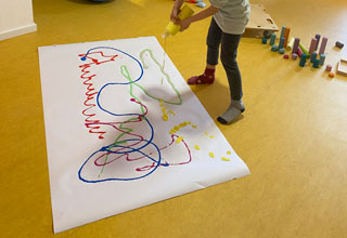 Kind malt auf großem Papier